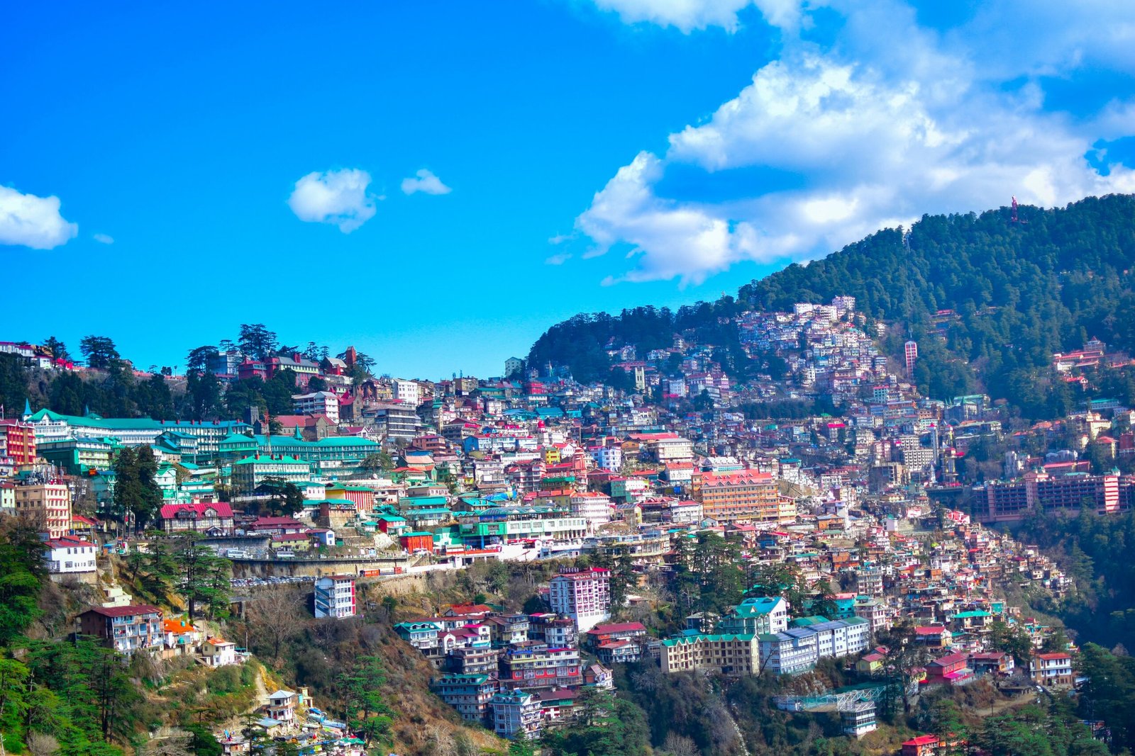 city near mountain under blue sky during daytime